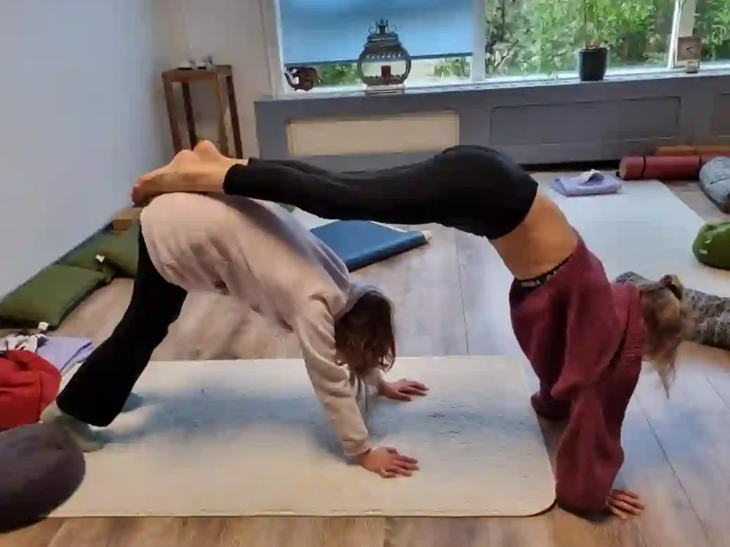 Twee kinderen in een partner yogahouding tijdens kinderyoga in de studio van Yogavisie in Opmeer